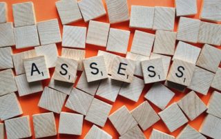 Scrabble tiles spelling "ASSESS".