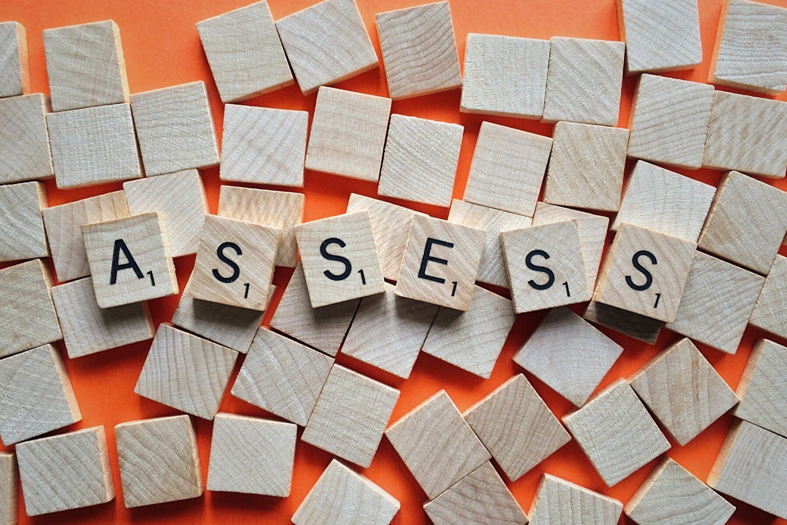 Scrabble tiles spelling "ASSESS".